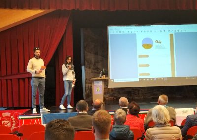 Inaugurazione evento Entener e se fèr entener  Loreta Florian e Conseier de Procura Amedeo Valentini, palco con pubblico