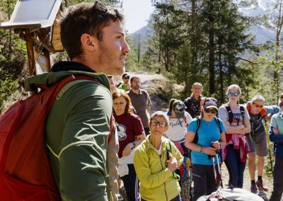 Persone in montagna in con panorama estivo e guida che spiega