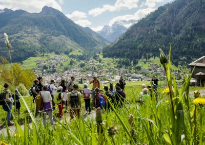 Panorama di montagna con gruppo di persone in escursione che ascoltano la guida